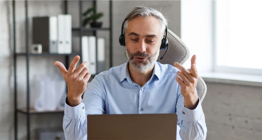 Banner for the 'Become a cPanel Partner' program, featuring a person wearing a headset on a video call, gesturing while looking at their laptop.